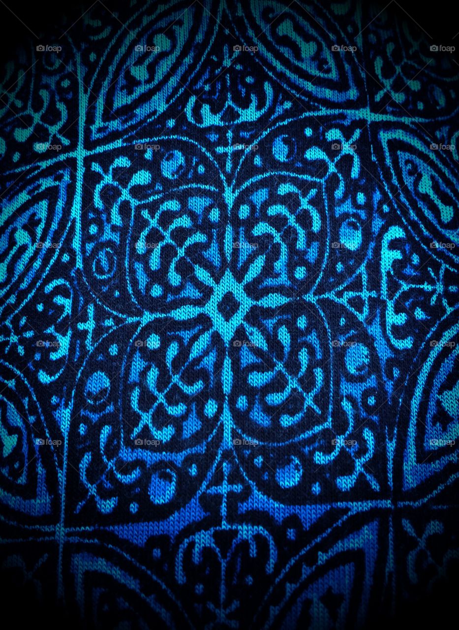 A bright pattern in shades of blue on cloth.