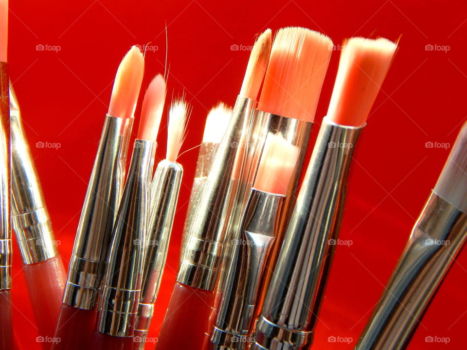 Pink make-up brushes on the red background