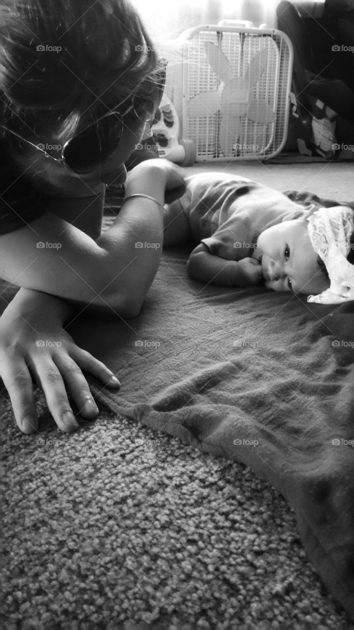 Mother and baby lying on carpet