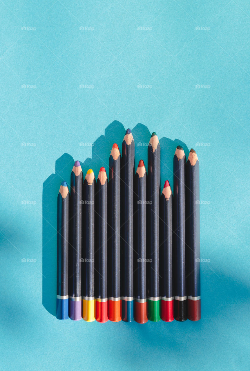 Crayons on a plain blue background. Copy space in the top