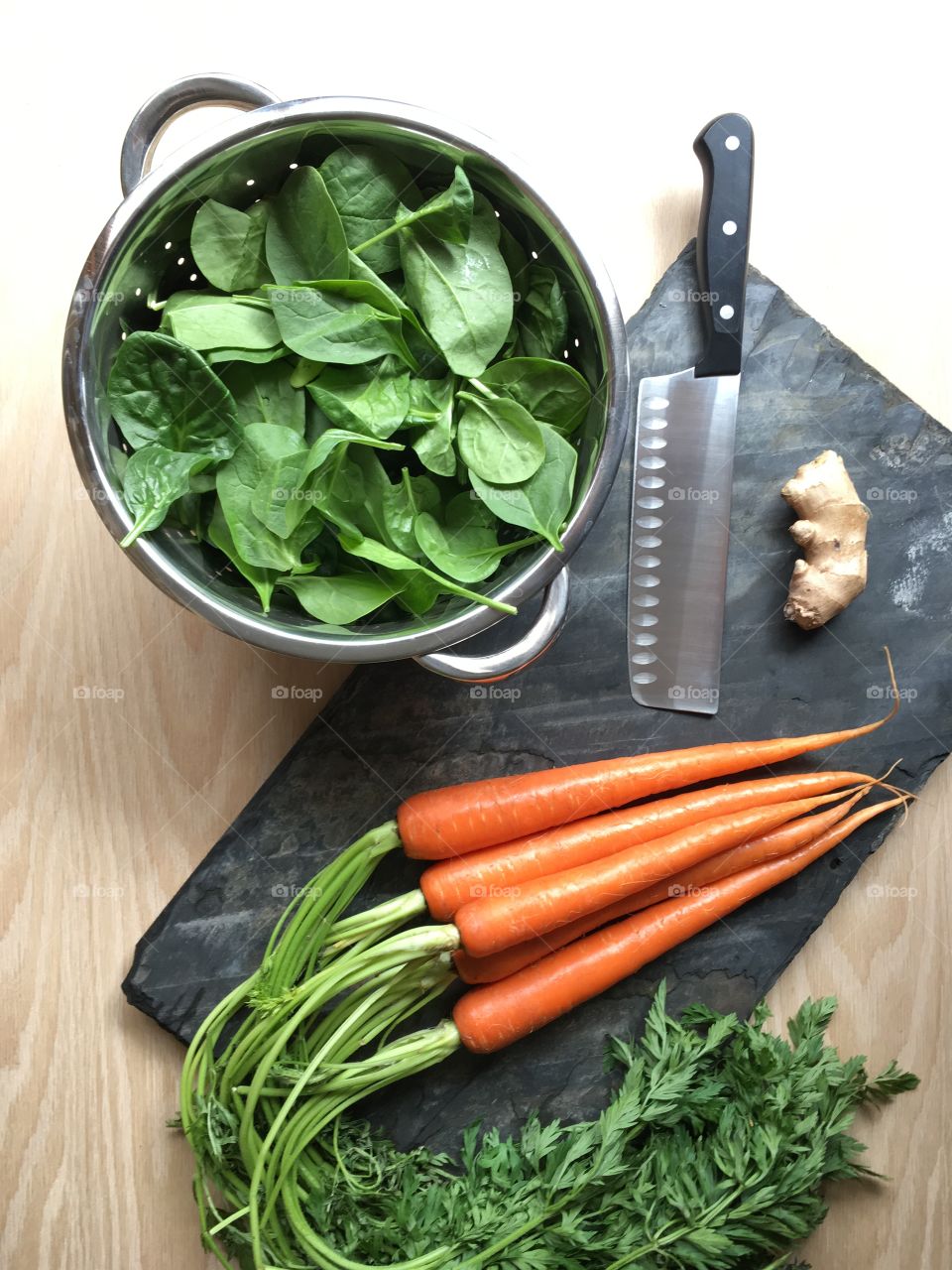 Cooking with fresh vegetables; baby spinach, organic carrots, ginger root. Healthy spring time meals.