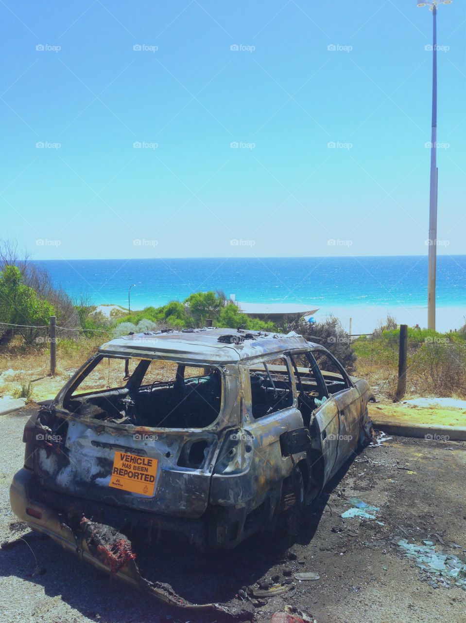 Burnt out car on beach. City Beach, Western Australia