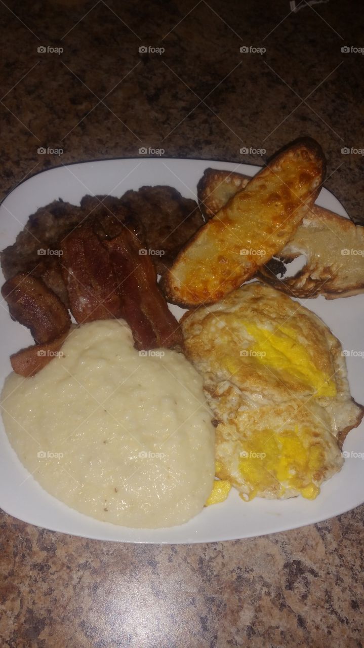 grits, eggs, bacon, sausage and cheese toast