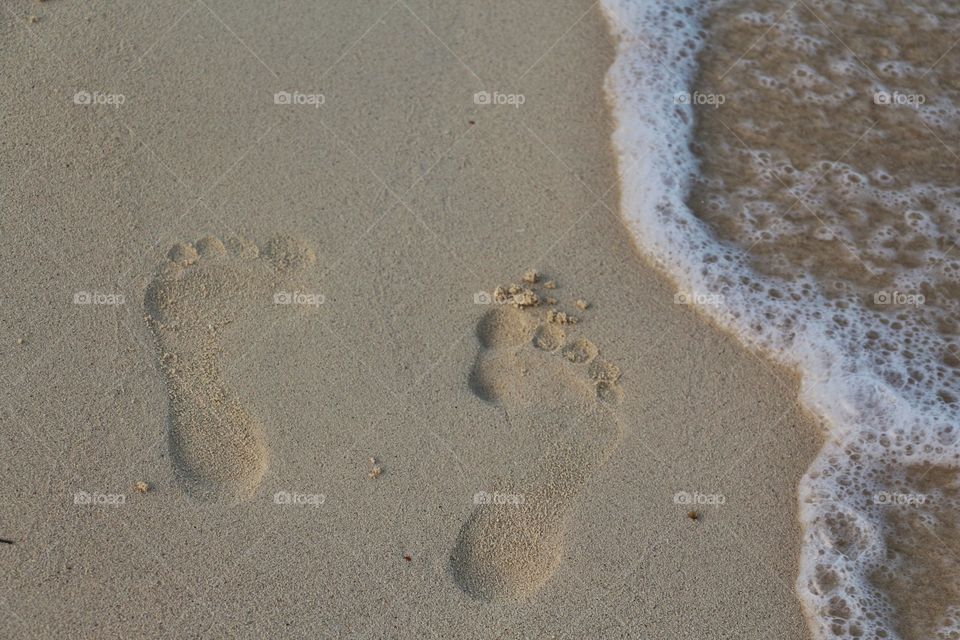 footprints on wet sand at coastline