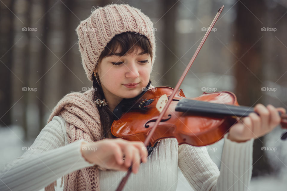 Teenage girl portrait with violin in winter park