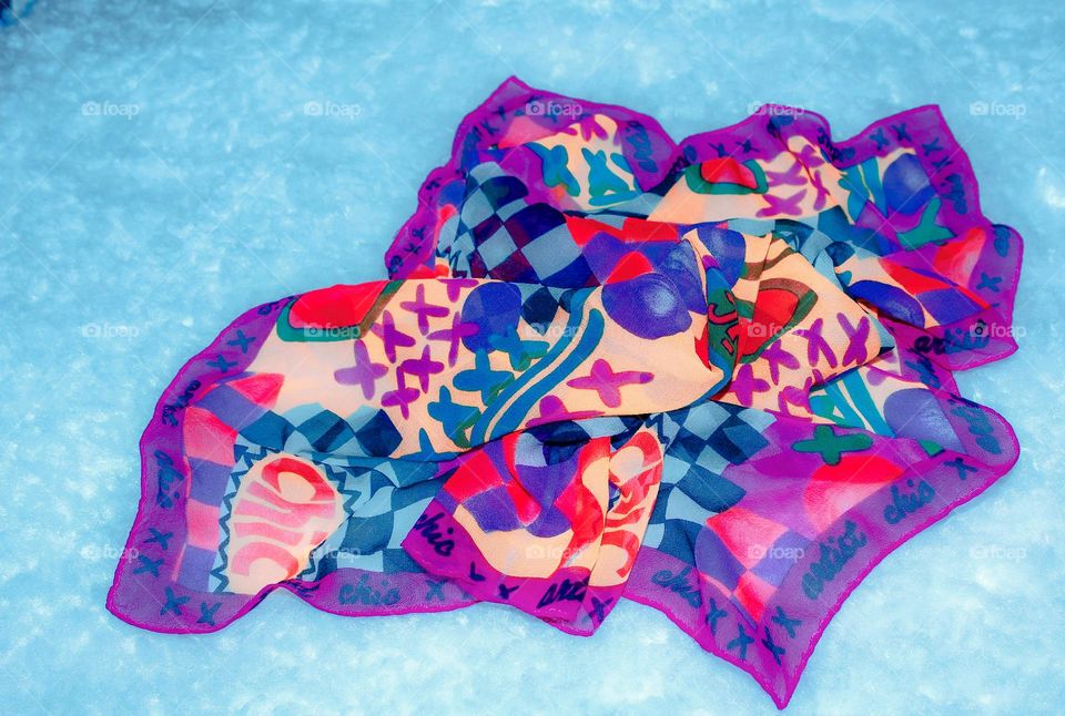 A pretty silk scarf of many colors on light blue background. 