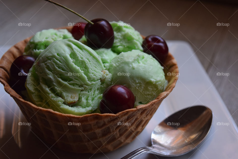 Scoop of pistachio ice cream with cherries