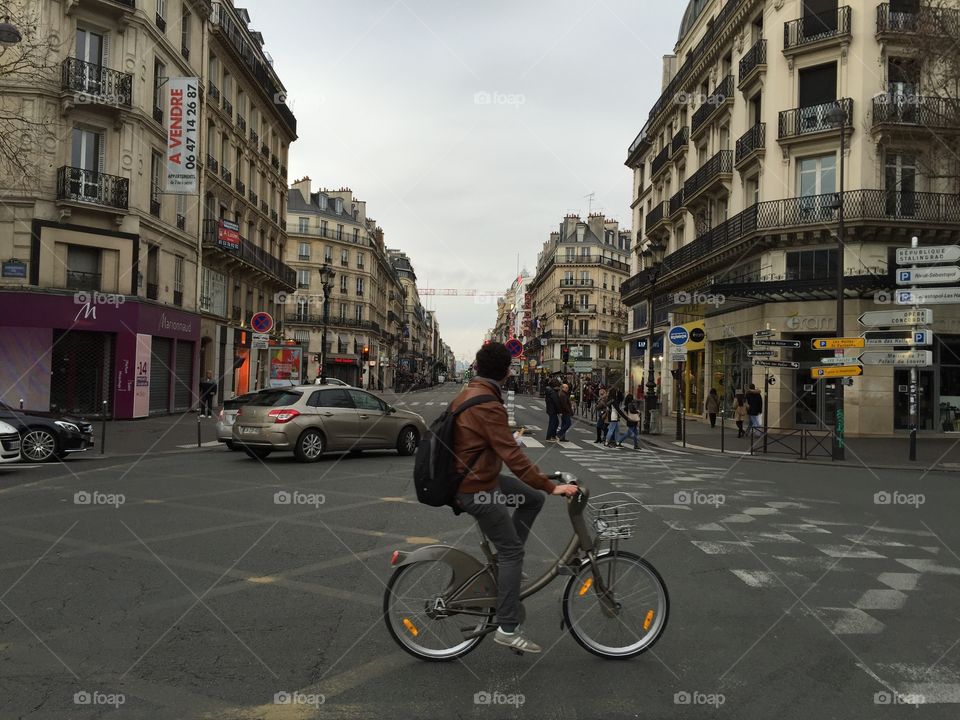 Person ride his bike in the middle of an intersection in a historic Paris.