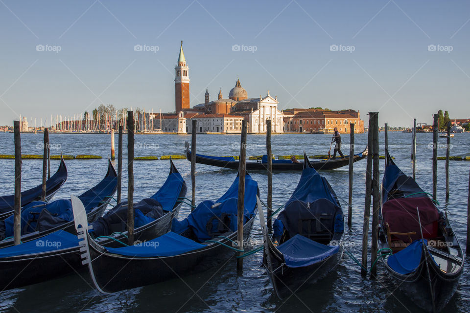 Gondolas at St Marc's square with gondolier rowing by. 