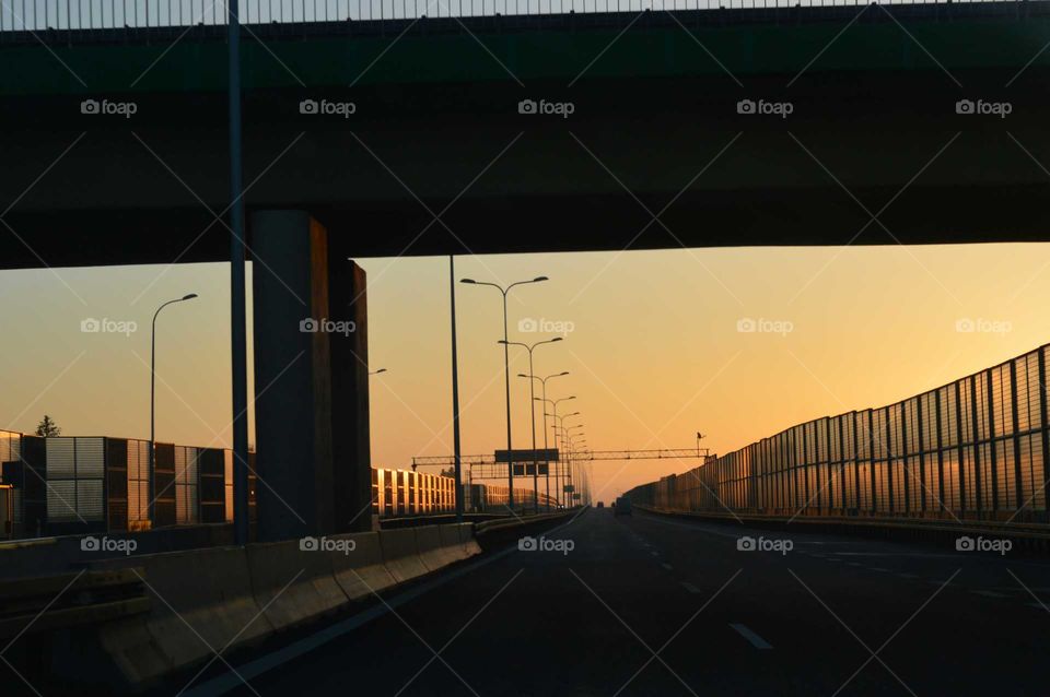 Golden hour during sunrise  on the expressway in Poland- driving under bridge