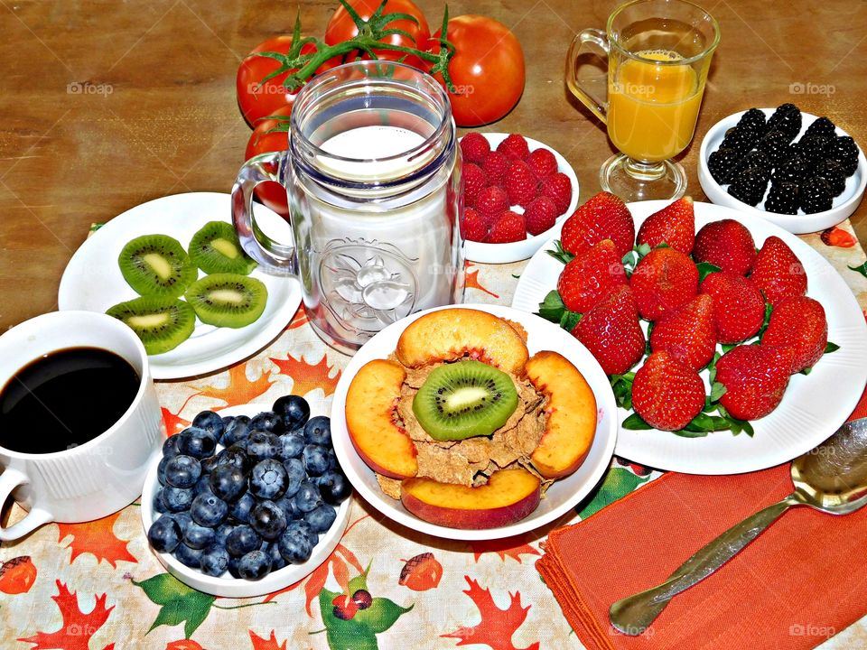 Fruit - A variety of fresh, colorful, prepared fruit lines the breakfast table, these are all healthy and nutritional 