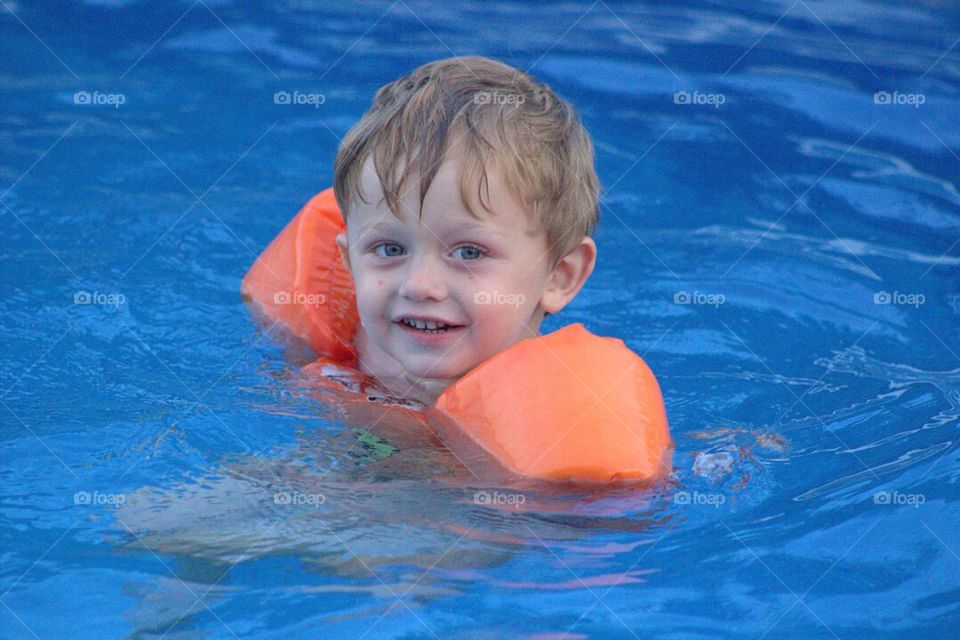Sweet litter toddler boy, happily swimming along. 