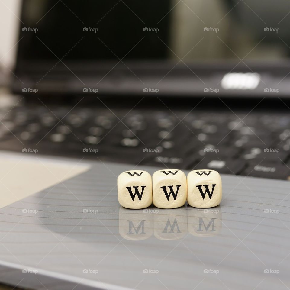 Close-up of www dice with laptop