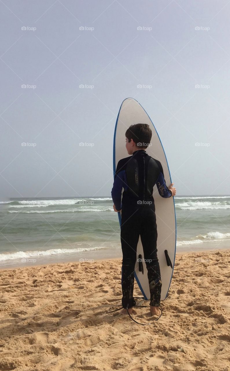 A grom looks to see how the surf is breaking at Yoff beach, Senegal