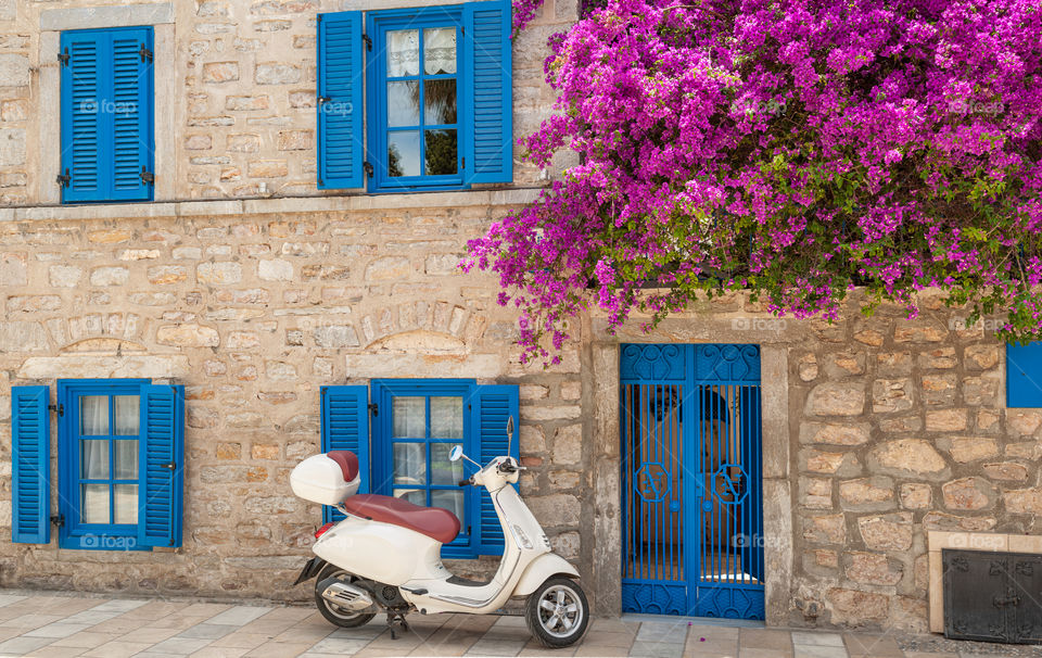 Scooter parked in front of beautiful house.