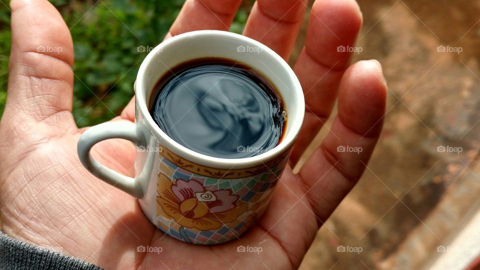 Cup of coffee in the palm of hand