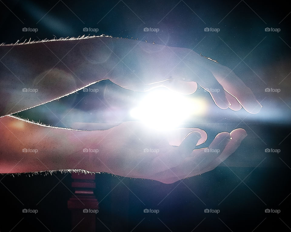 Close-up of a person's hand in front of light