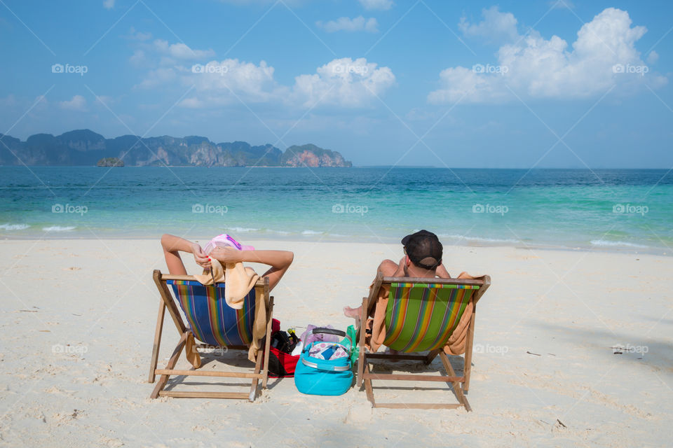 Lover chilling on the chair on the beach 