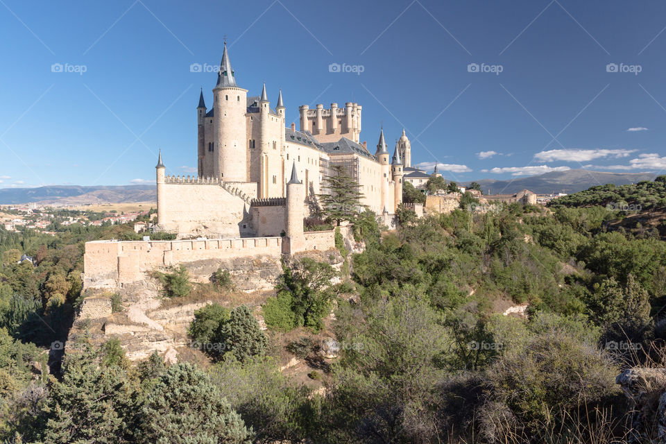 The Alcazar de Segovia, medieval fortress raising out on a rocky crag in a sunny day