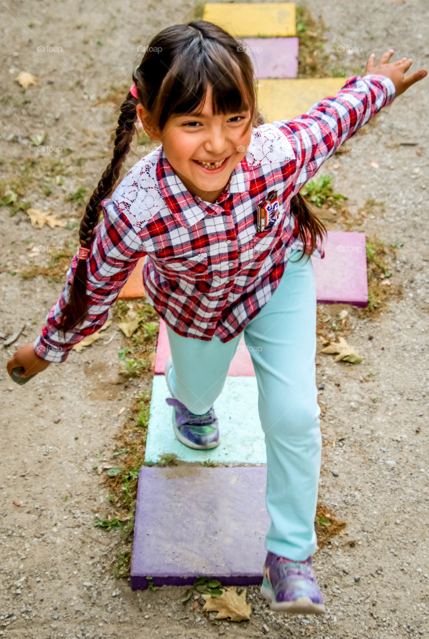 Full of energy child is playing hopscotch