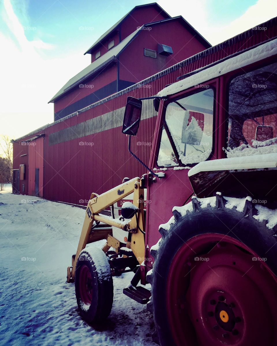 Red tractor covered in snow