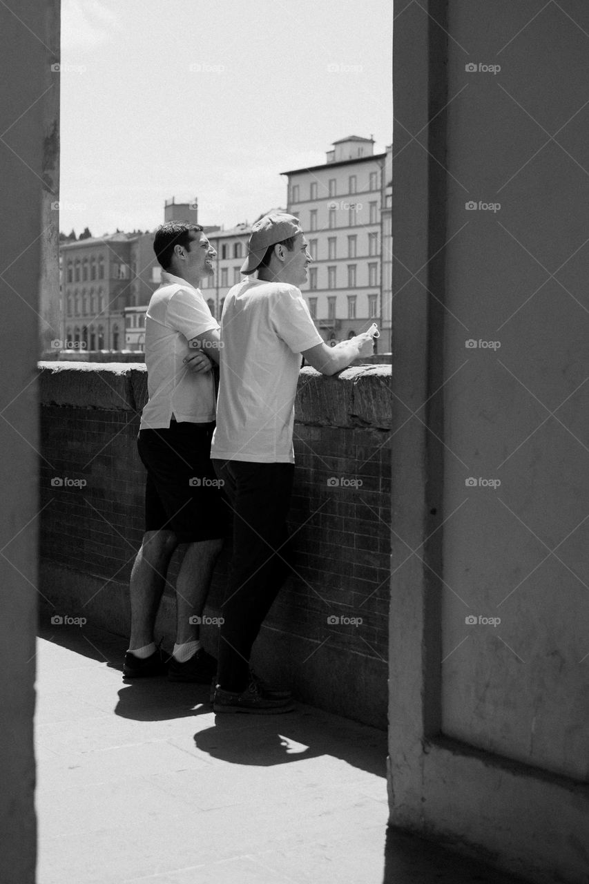 Young men watching something interesting on the other side of the Florence river