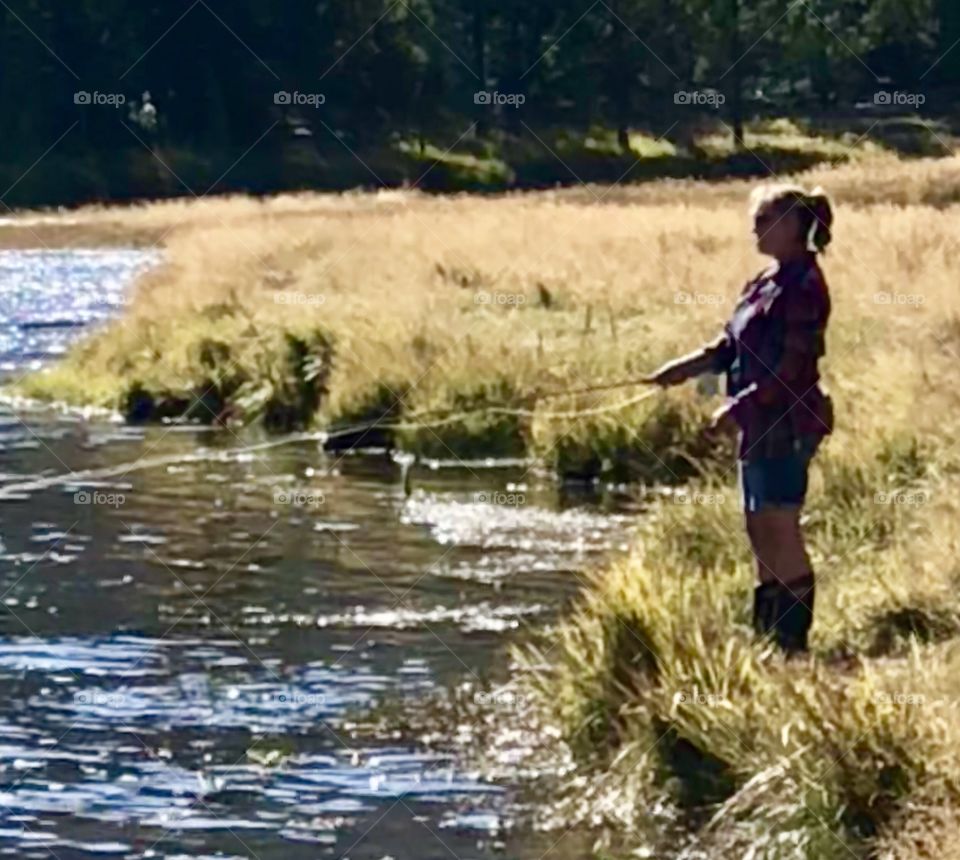 Fly fishing off the river bank