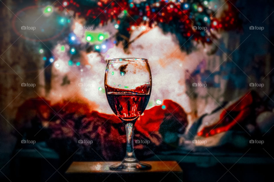 A glass of wine under the Christmas tree at the present box