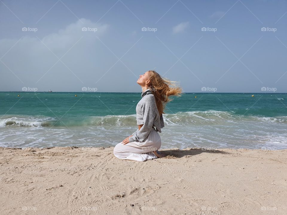 Woman doing yoga outside by the beach
