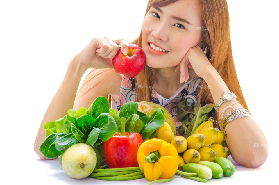 A young Asian cute girl holding an apple with happy face. This picture shows that fruits and vegetables are beneficial to human body.