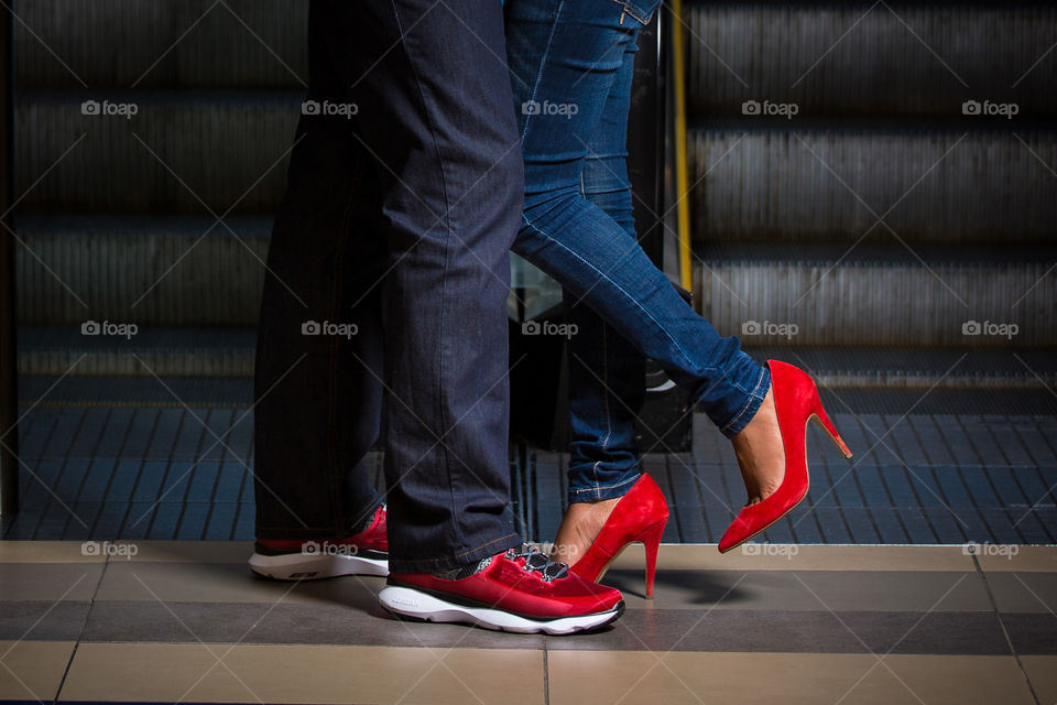 The color red for this composition. image of couple standing wearing red shoes. Romantic feel to image.