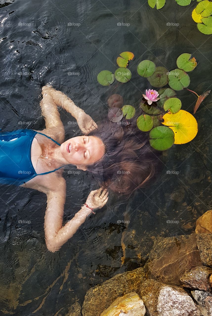 woman with lomg hair in the pond with waterlilies