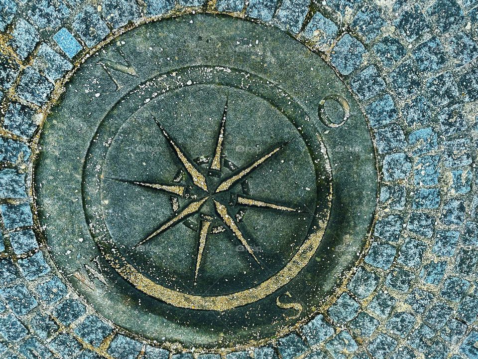 Close up of a compass on a sidewalk