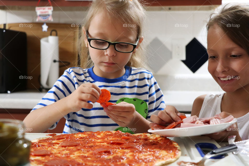 Siblings making pizza