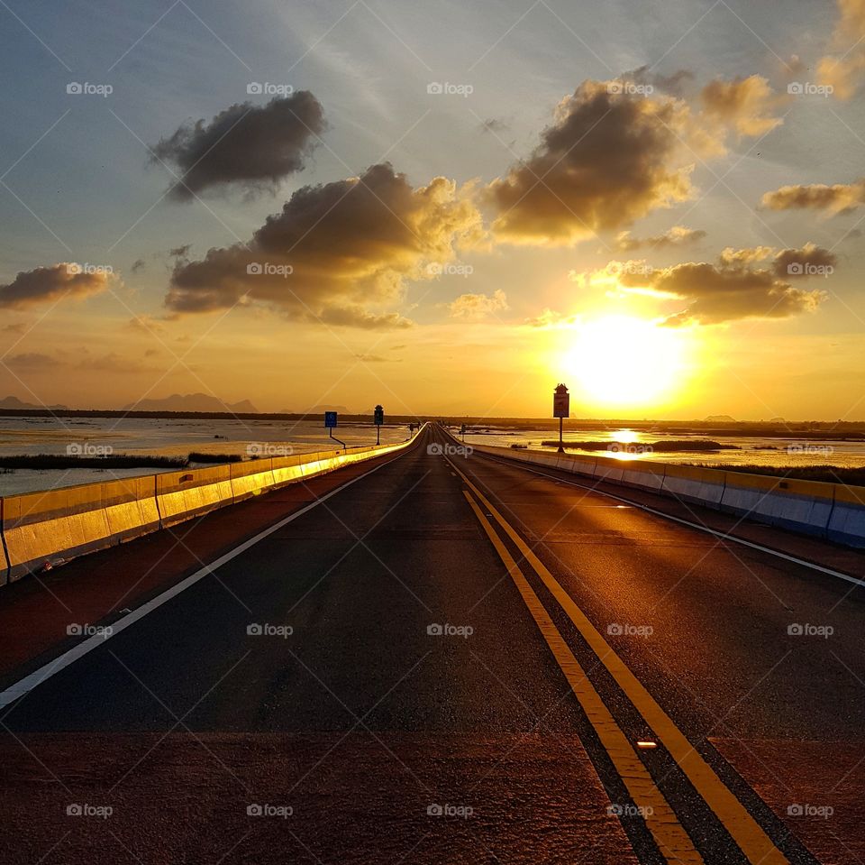 Along the road with sunset sky and sunrays background