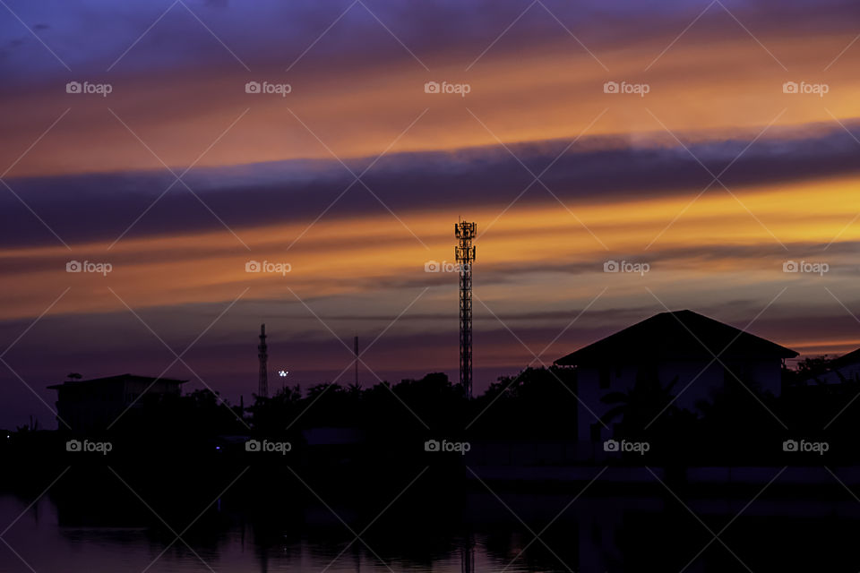 Beautiful light of sunset is orange after the telephone receiver antenna.