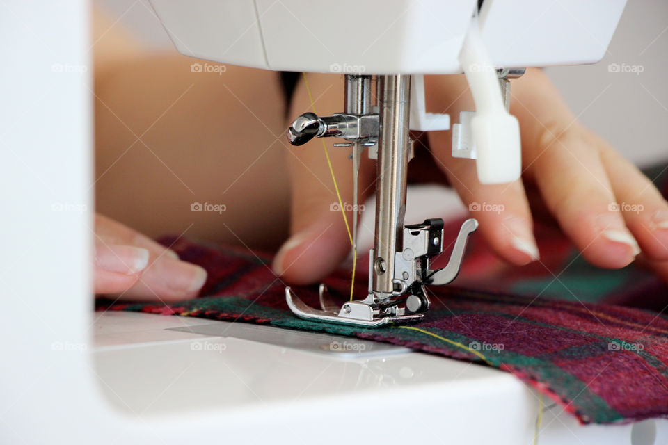 Detail of sewing machine and busy hands