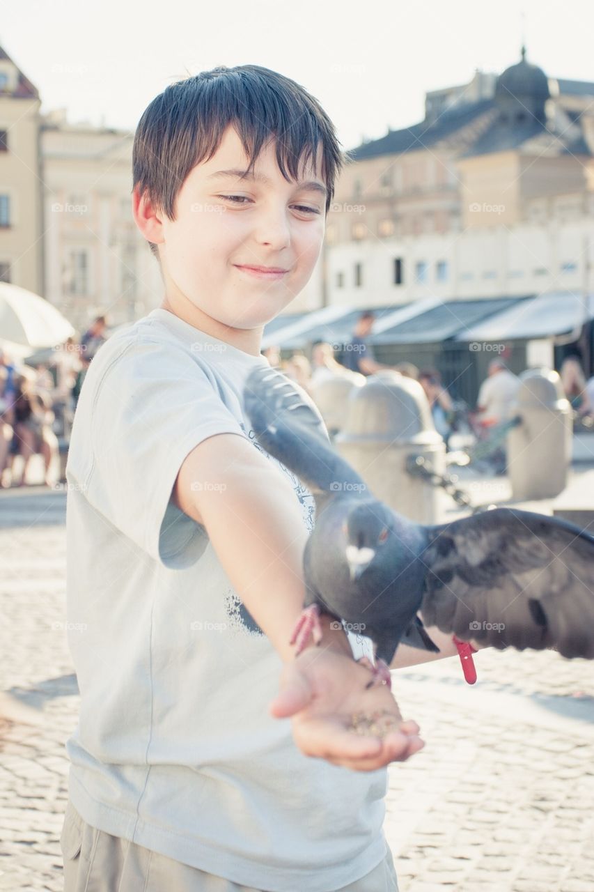 Boy feeding pigeon