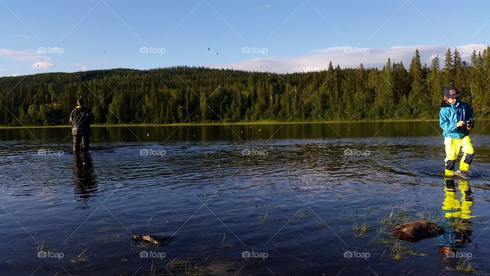 Little boy fishing in lake