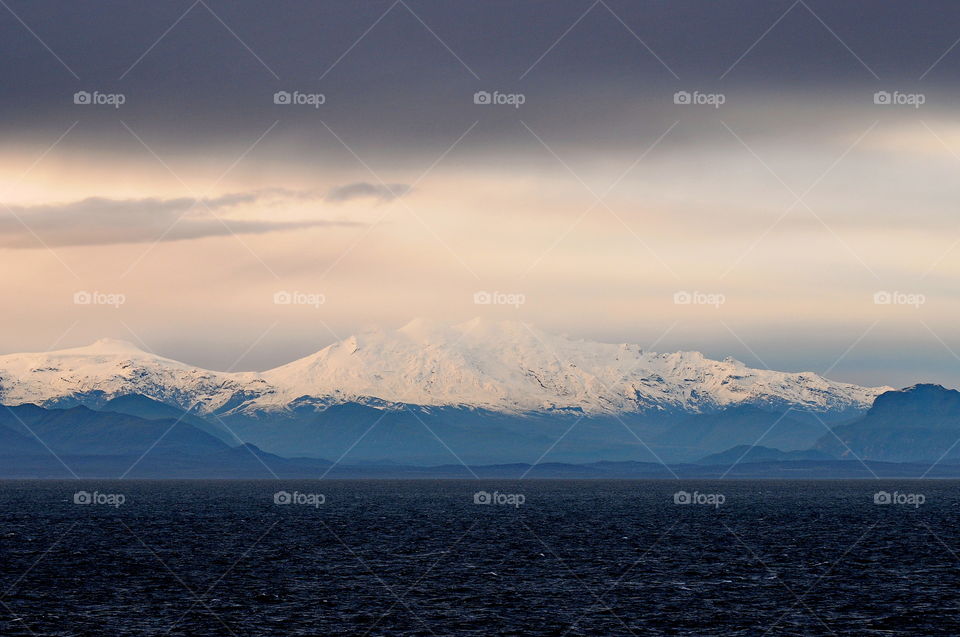 A view of the snow capped peaks of the Andes Mountains while sailing to Puerto Montt, Chile.