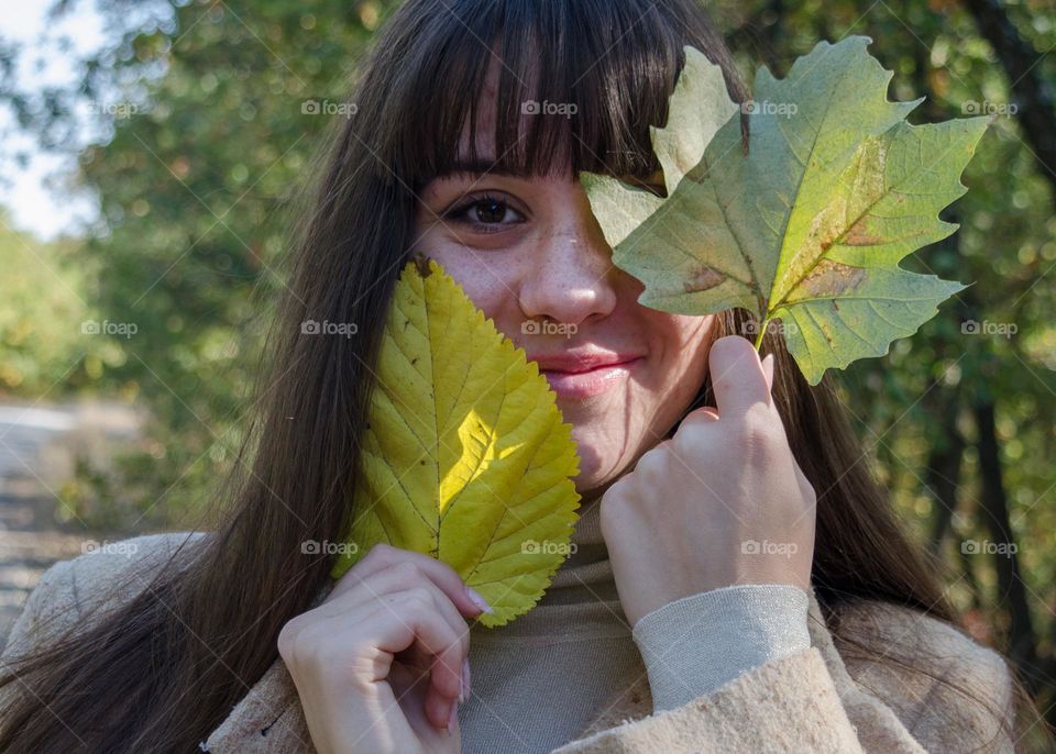 Smiling Young Girl on Autumn Background