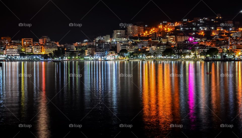 City Saranda Lights Reflected on Body of Water During Night