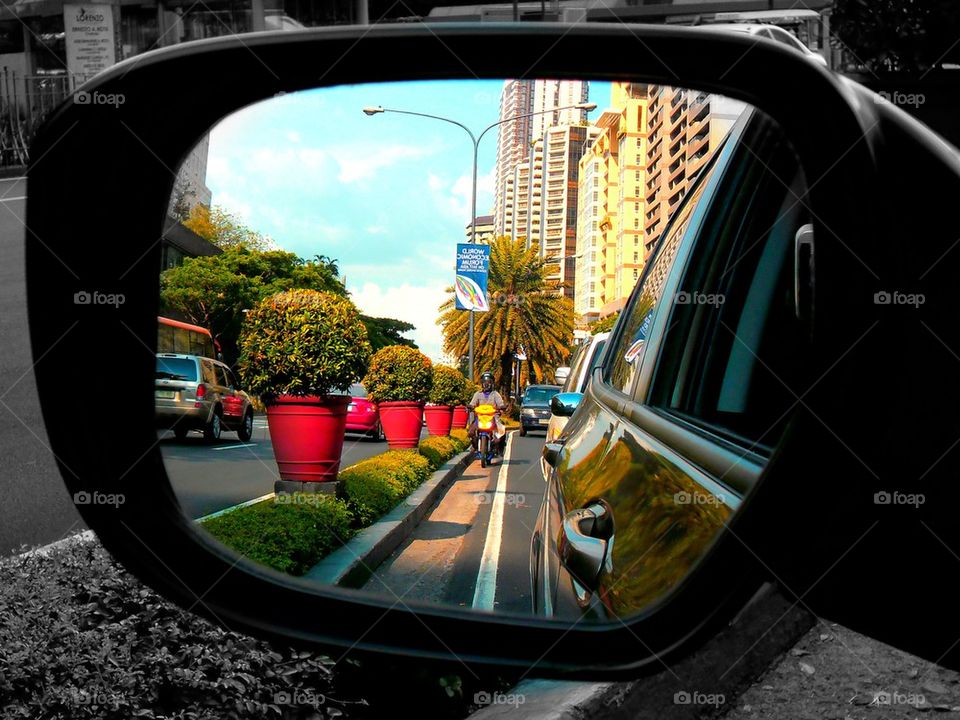 view of a street through a car's side view mirror