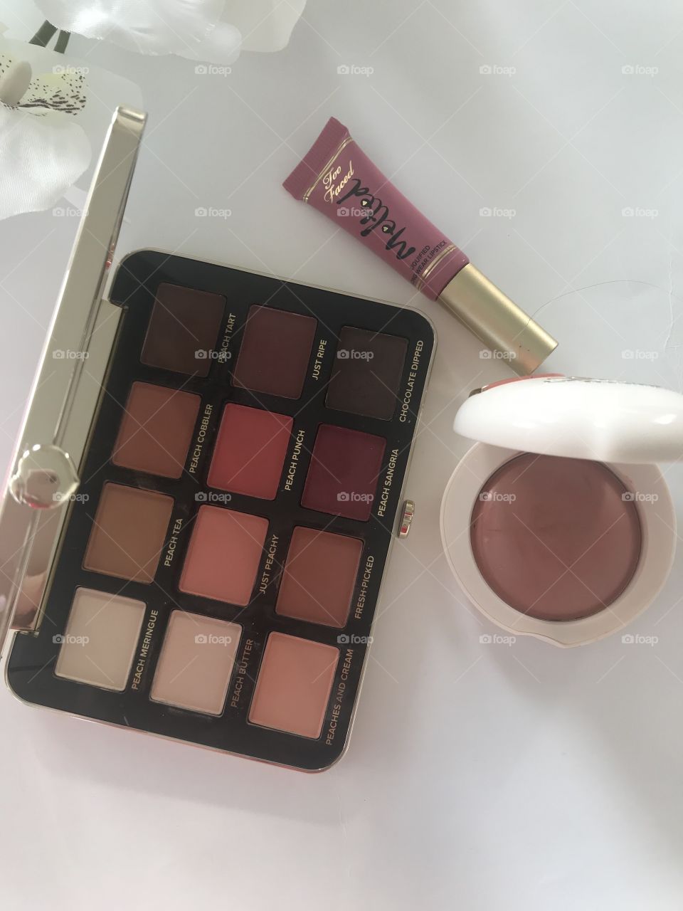 Peach flat lay makeup with eyeshadow palette 