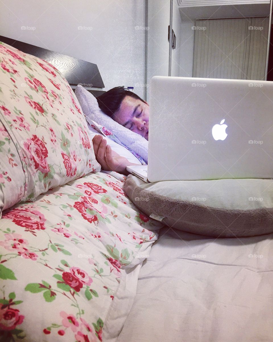 Man sleeping on bed with laptop
