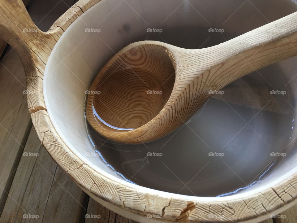 Ladle in clear water with reflection In wooden sauna bucket conceptual healthy lifestyle and beauty routine body care background photography 