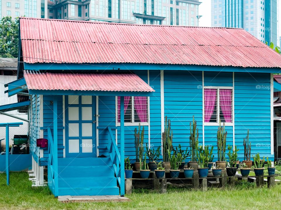 A blue timber house with pink curtain in Kampung Bahru, Kuala Lumpur Malaysia