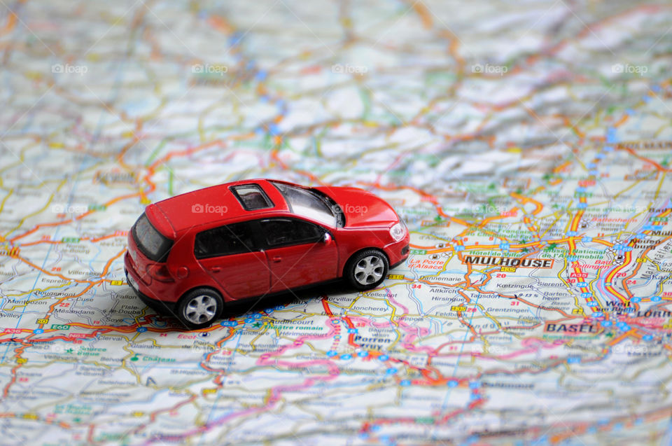 a toy red car on the map background