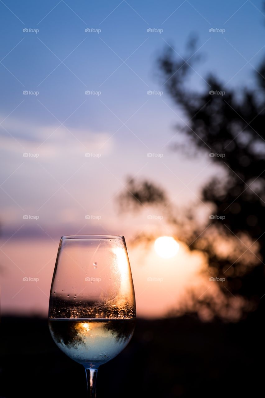Glass of wine in Santorini. Enjoying a glass of white wine while the sun is going down in Santorini, Greece.