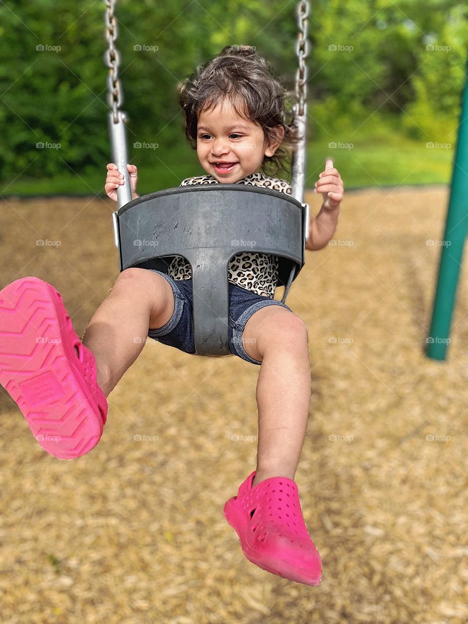 Toddler kicks legs while swinging, being silly on the swing with Mommy, at the park with Mommy, crazy fun on the swing 